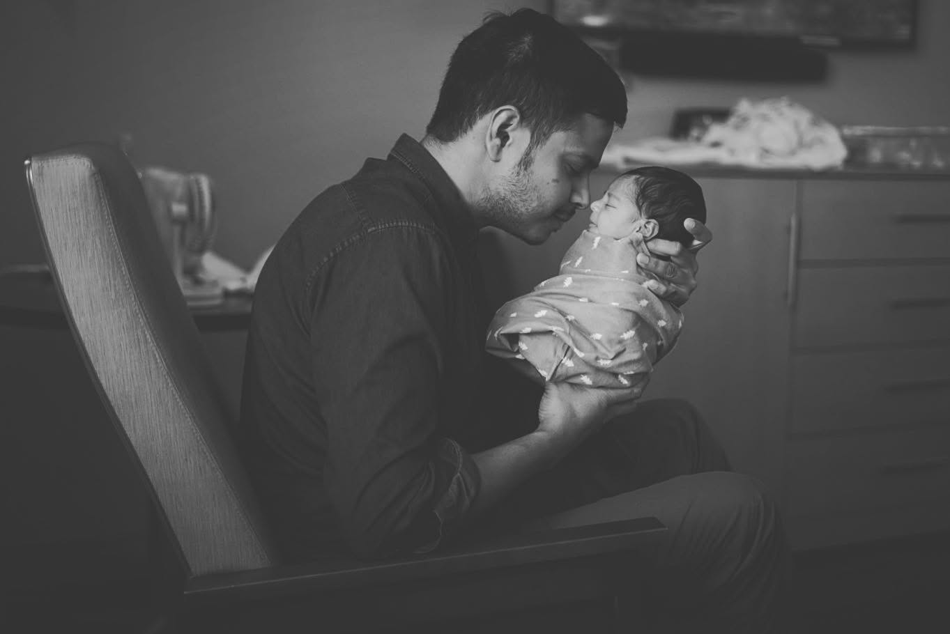 Naser holding his newborn son